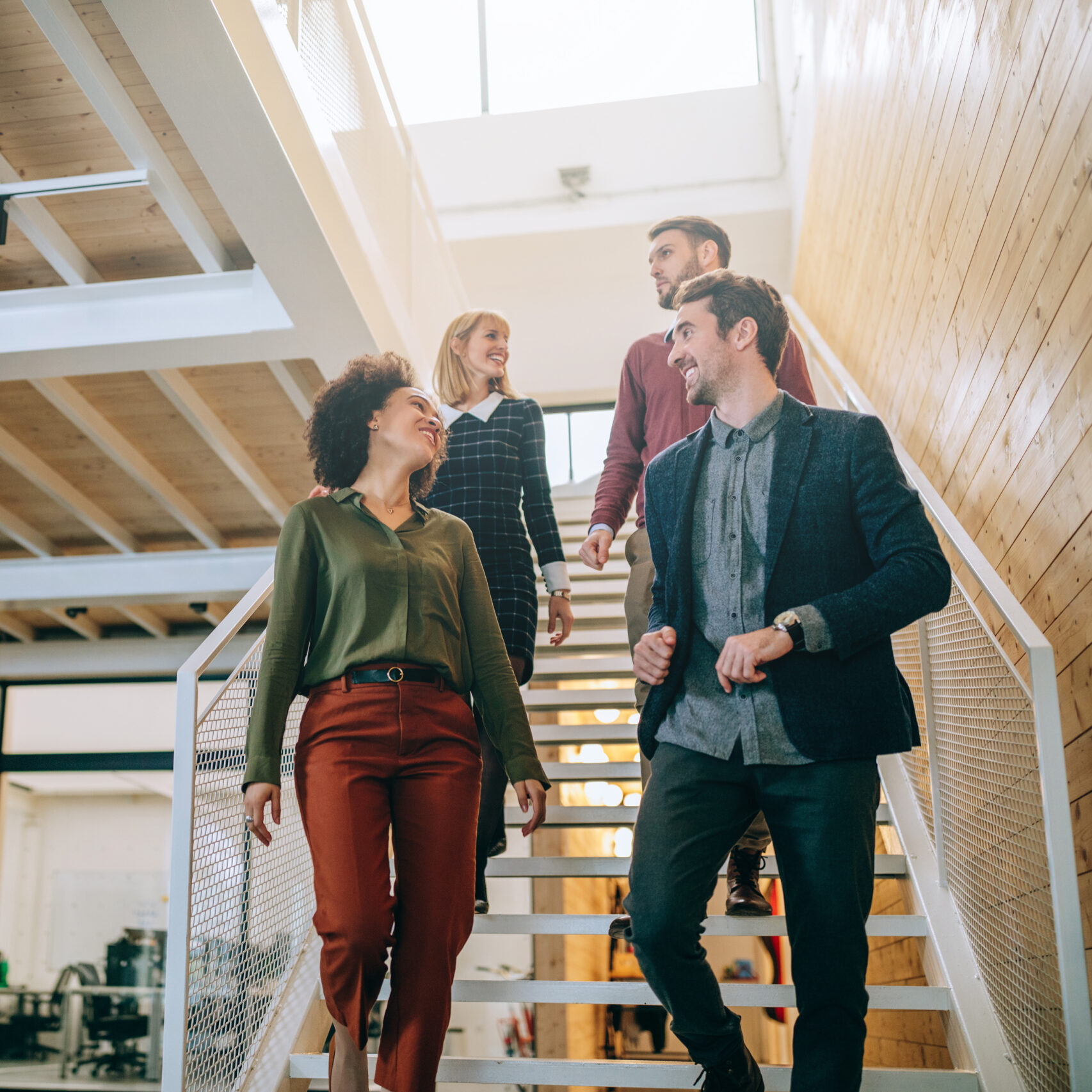 Group of diverse coworkers walking down the stairs in an office